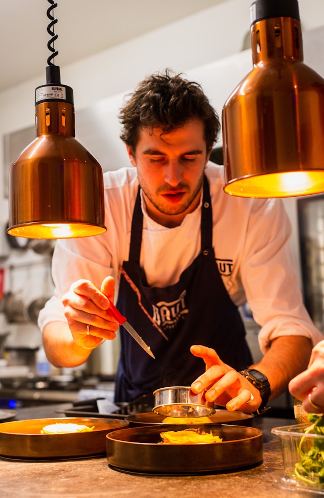 Chef preparing food in a busy restaurant kitchen